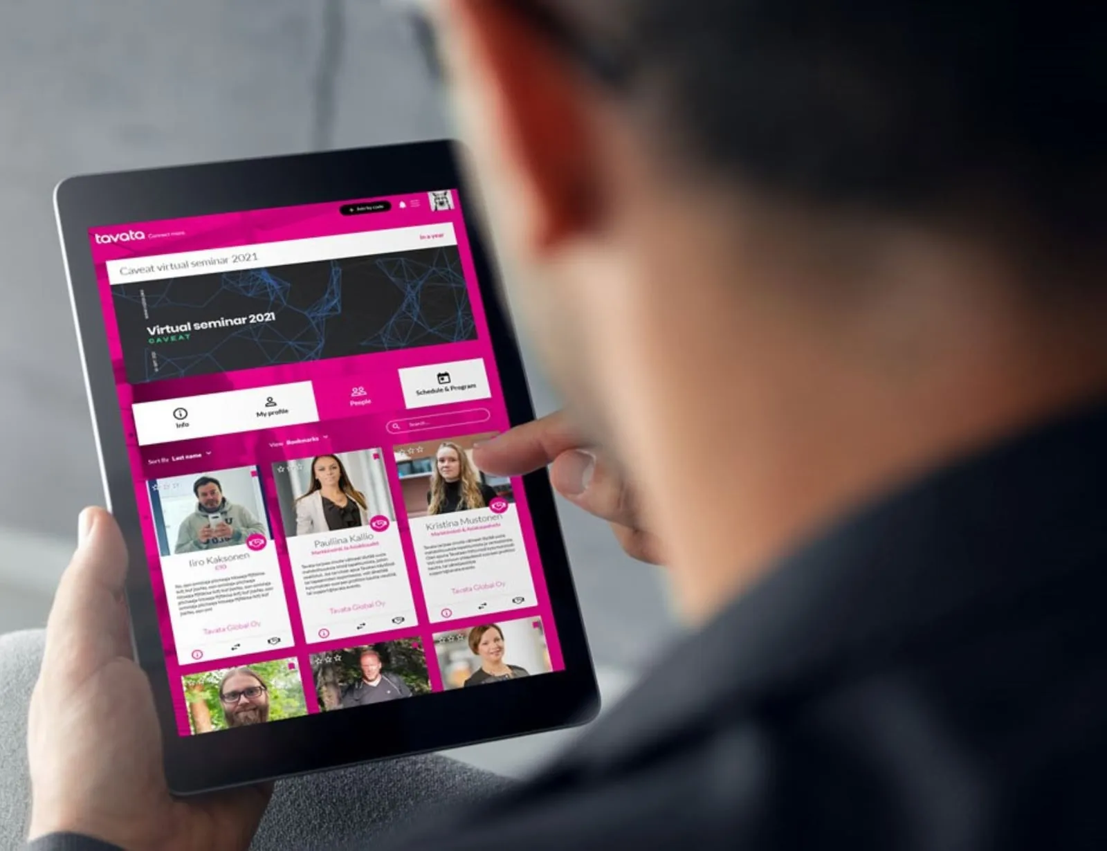 A tablet showing a Tavata virtual seminar with its program tabs and attendee cards