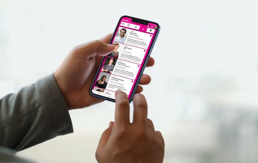 A phone showing Tavata attendee profiles at an event