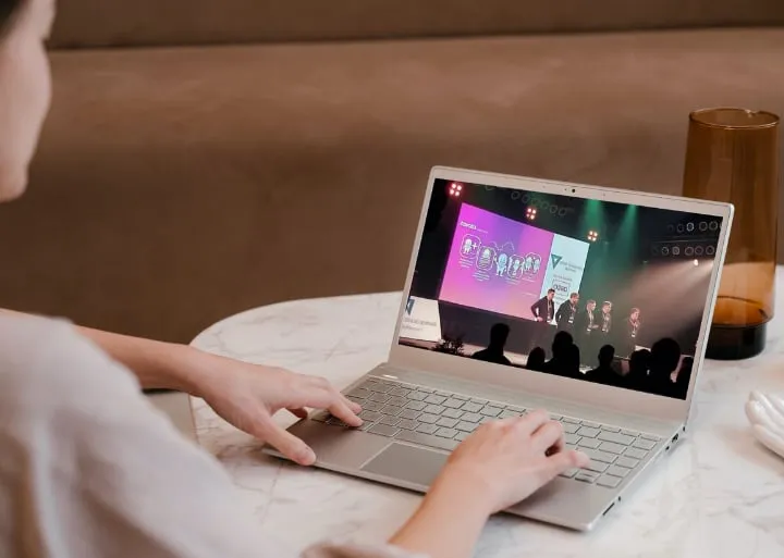 A woman at a laptop watching a stage stream in the Tavata event program view