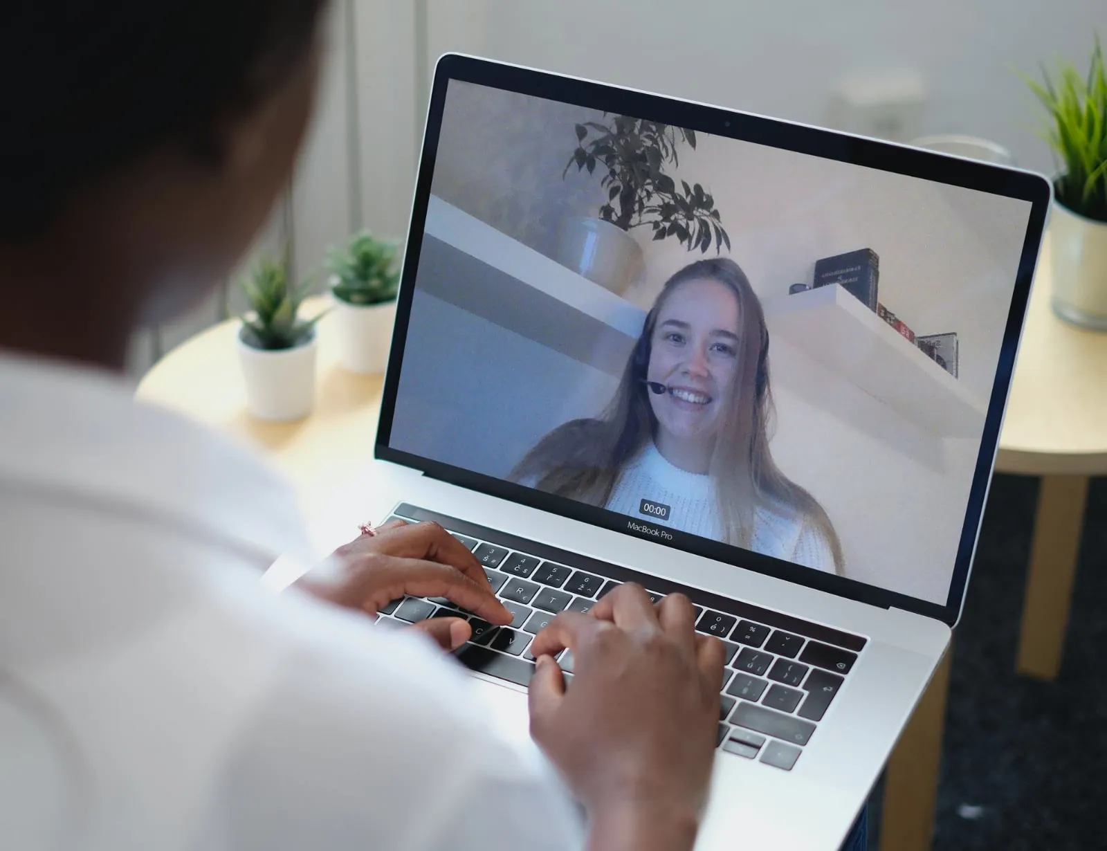 A person in a Tavata video meeting with another attendee on a laptop screen